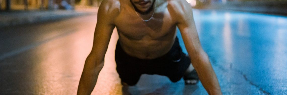 topless man in black shorts kneeling on floor
